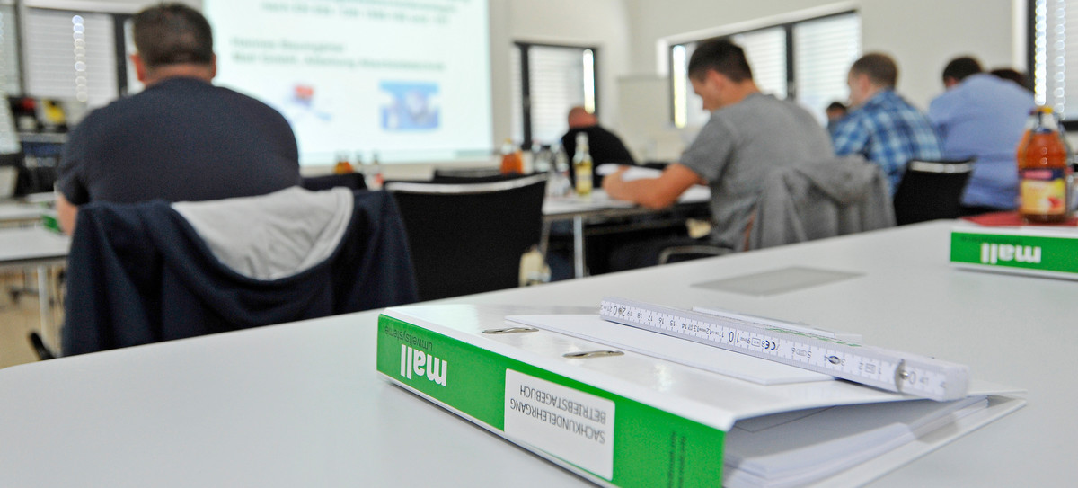 Schulung im Seminarraum mit Teilnehmern, Präsentation im Hintergrund und Mall-Unterlagen auf dem Tisch – Mall Umweltsysteme